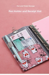 Pink budget binder interior with card slots, metal rings, and a pen holder for saving