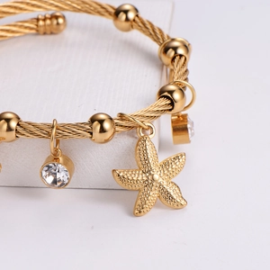 Gold braided wire rope bracelet featuring starfish charms and sparkling crystals