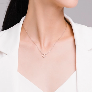 Collier minimaliste en argent S925 avec pendentif cœur ajouré porté par un mannequin chic
