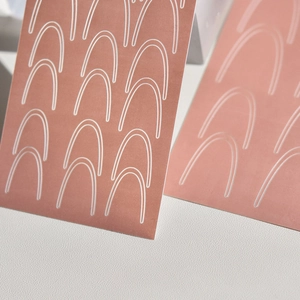 Terracotta hollow spray nail stencils with white geometric arch line patterns