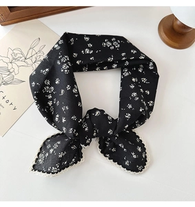 Detail of black floral cotton scarf featuring white flower prints and lace trim edge