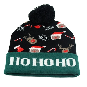 Close-up of knit Christmas beanie with HO HO HO text on the green cuff and pom-pom