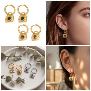 Détails des boucles d'oreilles créoles avec pendentif cadenas et pierres précieuses