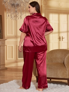 Detail of burgundy satin pajama sleeve and pants hem with contrast piping detail