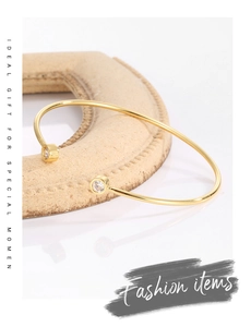 Polished 18K gold-plated cuff bangle featuring dual round cubic zirconia in a macro view