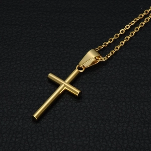 Polished gold stainless steel cross pendant necklace displayed on black leather