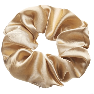Detail of champagne gold satin scrunchie showing smooth texture and elegant silk sheen
