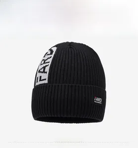 Detailed view of black ribbed knit beanie with white FARD jacquard lettering and tag
