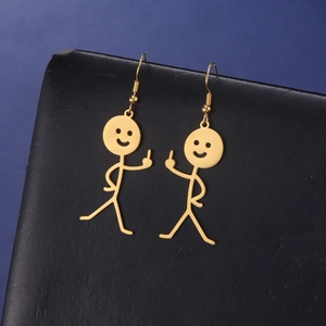 Detailed view of golden stick figure earrings with middle finger pose on black display