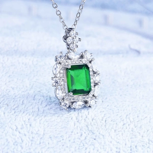 Close-up of emerald-cut green crystal pendant with micro-pave crystals on silver necklace