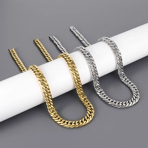 Detail of 12mm gold and silver titanium steel Cuban link chains on a white cylinder stand