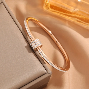 Elegant rose gold plated titanium steel bangle with inlaid diamonds on premium silk