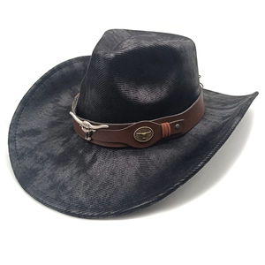 Detail of black suede cowboy hat featuring brown leather band and metallic bull head ornament