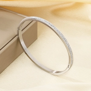 Dettaglio del bracciale in acciaio argentato con doppia fila di pavé su seta morbida