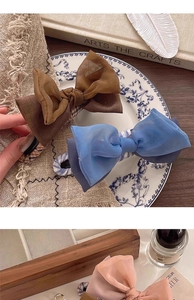 Detailansicht eleganter doppellagiger Chiffon-Haarschleifen in Braun, Blau und Rosa