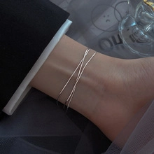 Detailed close-up of a minimalist silver double-layer ankle bracelet for women