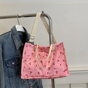 Pink cherry print canvas tote bag with outer pockets and adjustable straps for women