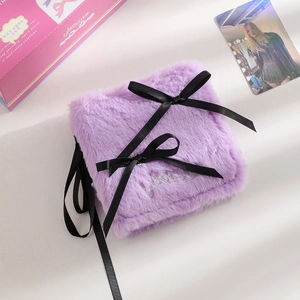 Detail of purple plush storage binder with black ribbons and silver embroidery