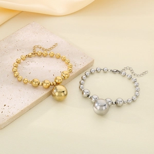 Detailed view of gold and silver beaded bracelets with large pendants on stone and silk