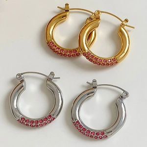 Close-up of luxury C-shaped hoop earrings with pink pave zircon in gold and silver finish