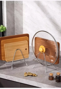 Close-up of stainless steel cutting board rack and pot lid holder in a modern kitchen