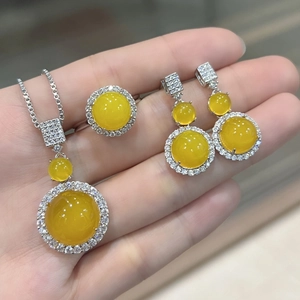 Close-up of silver jewelry set with round yellow chalcedony stones and small diamonds