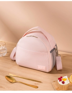 Detail of light pink insulated lunch bag with top handle and adjustable shoulder strap