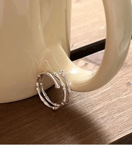 Detailed macro view of an irregular bamboo-style S925 silver ring on a ceramic cup
