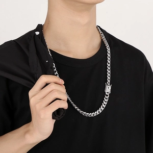 Detail of silver Cuban chain with diamond-encrusted square clasp on a male model