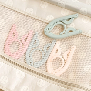 Portable folding travel clothes hangers in pastel colors with compact storage mesh bag