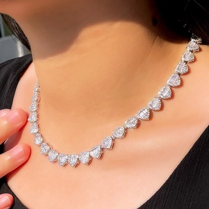 Detailed close-up of heart-shaped cuban links featuring baguette and round zircon stones