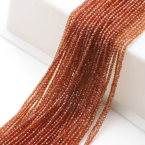 Macro shot of 2mm amber faceted glass beads neatly arranged for jewelry making
