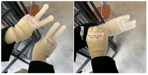 Detail of beige knitted gloves with handmade labels and touchscreen compatibility