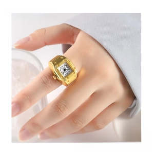Macro shot of a vintage gold ring watch featuring a square bezel with rivet details