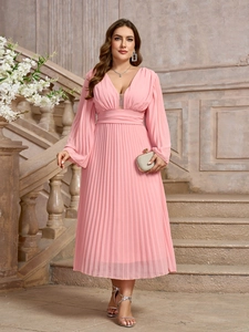 Dettaglio della texture in chiffon a pieghe e scollo a V su un abito rosa a maniche lunghe