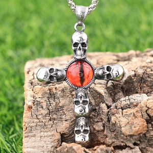 Gothic stainless steel skull cross pendant with red gem stone on rustic wood background
