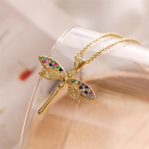 Macro shot of dragonfly pendant featuring colorful zircons and golden hollow wings