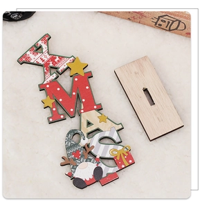 Close-up of DIY XMAS letter wooden ornament with Santa and gift box on white plush base