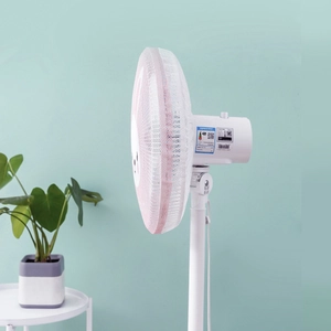 Pink polyester mesh electric fan safety cover on pedestal fan in minimalist home setting