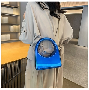 Detail of bright blue acrylic handbag with circular hollow handle and metal chain strap