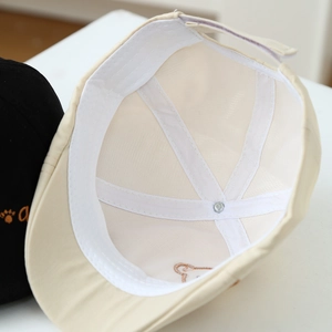 Macro view of cotton beret inner lining with reinforced seams and embroidery detail