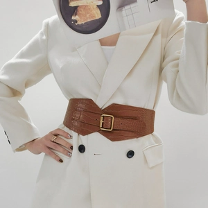 Detail of wide brown crocodile pattern belt with golden square buckle on white blazer