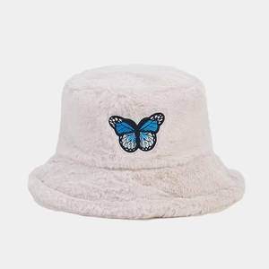 Close-up of soft plush bucket hat featuring a delicate blue butterfly embroidery detail