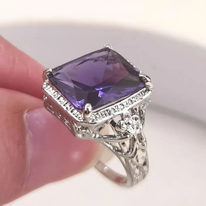 Vintage silver ring featuring a rectangular purple gemstone with intricate floral engravings