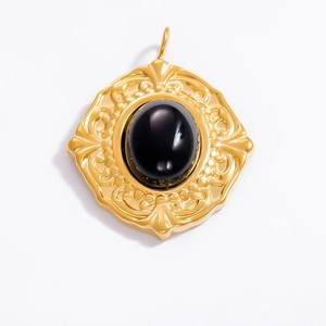 Close-up of vintage baroque 18k gold pendant with oval black obsidian and floral relief