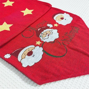 Detail of red Christmas table runner featuring knitted Santa Claus and Merry Christmas text