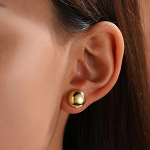 Detailed close-up of a high-shine 18k gold plated geometric spherical stud earring