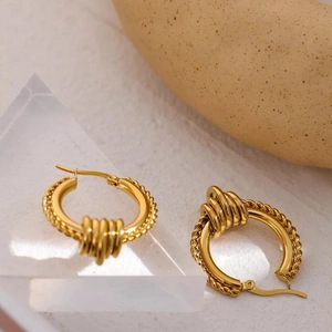 Chic twisted rope gold stainless steel hoop earrings on a decorative prism