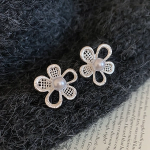 Detailed macro of hollow floral earrings with S925 silver mesh petals and white pearls
