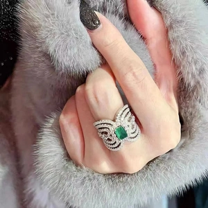 Luxury butterfly ring with green square gem and micro-pave diamonds on silver band